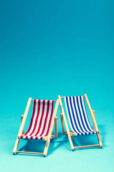 Two lounge chairs on blue background with copy space