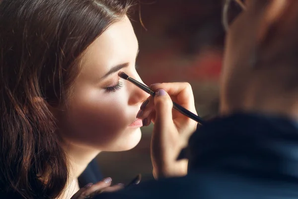 Makeup artist applies nude makeup to emphasize the natural beaut