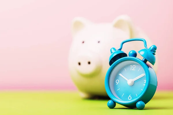 Alarm clock and piggy bank with copy space, close-up. Concept -