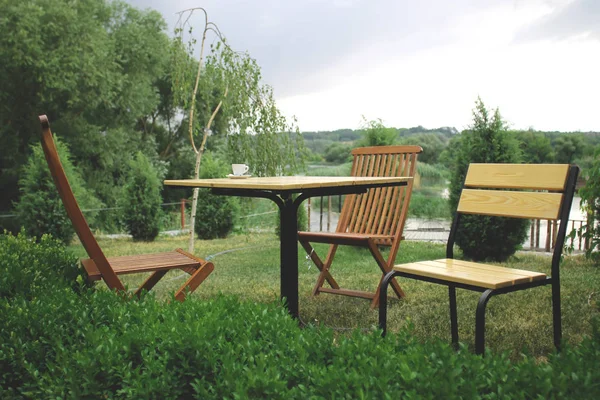 Üç sandalye ve Bahçe Nehri yakınında bir tabloda