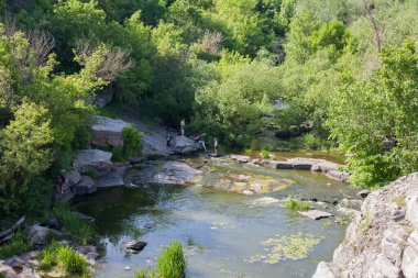 Buky, Cherkasy bölgesi, Ukrayna - 6 Haziran 2020: Girskyi Tikych Nehri 'ndeki granit kayalıklarda turistler