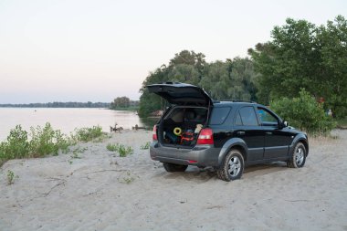 Cherkasy, Ukrayna - 10 Temmuz 2020: Dnipro nehri yakınlarında gün batımında KIA Sorento