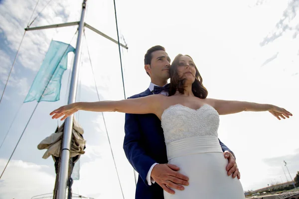 Couple of newly married lovers dance on the deck of a sailboat