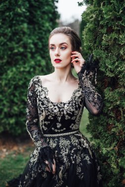 siyah gece elbisesi yeşil ağacın yanında, closeup poz çekici genç kadın