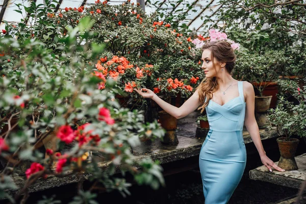 Молодая Женщина Синем Платье Позирует Ботанической Оранжерее Цветущими Цветами — стоковое фото