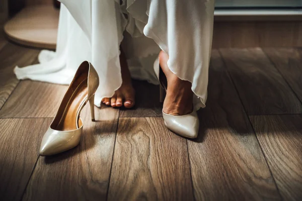 Close-up of feet of woman in elegant gown wearing stylish shoes