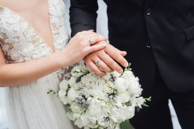Gelin ve damat nikah yüzükleri ve buket elinde Close-Up 