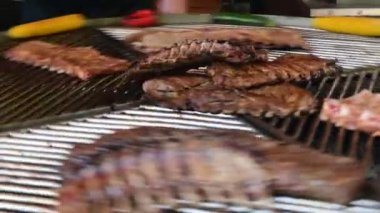 Füme kaburga ve mısır dönen yuvarlak ızgara kızarmış. Sokak gıda, sağlıklı 4k video