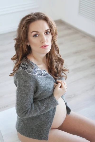 Kobieta w ciąży, siedząc na krześle biały — Zdjęcie stockowe