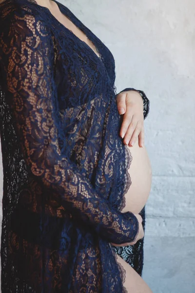 그녀의 배꼽을 포옹 하는 블루 실내에 임신한 여자 — 스톡 사진