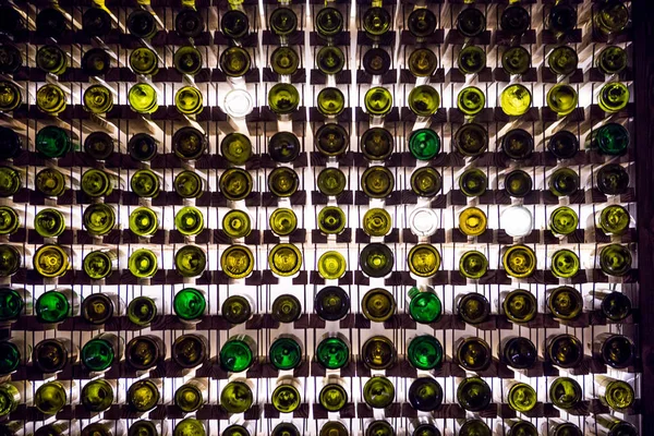 Wall of empty wine bottles. Empty wine bottles stacked-up on one another in pattern lit by the light coming from behind