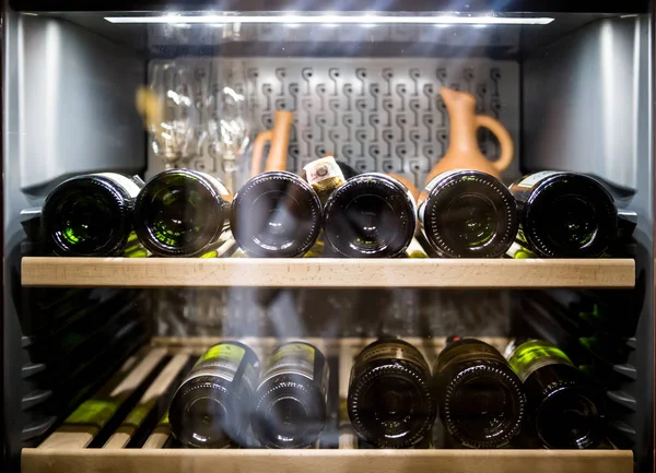 Botellas de vino enfriamiento en nevera Imágenes De Stock Sin Royalties Gratis