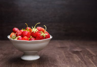 kase ahşap arka plan üzerinde kırmızı çilek