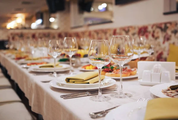 Glaswerk en bestek voor catered evenement. Instelling van de mooie tafel met servies voor een feest, bruiloft receptie of een andere feestelijke gebeurtenis — Stockfoto