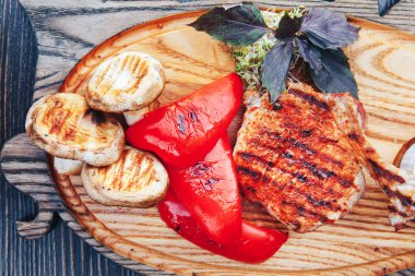 Kemik ve sebze ve ahşap tahta kesme üzerinde Barbekü sos ızgara antrikot biftek. Sıcak et yemekleri