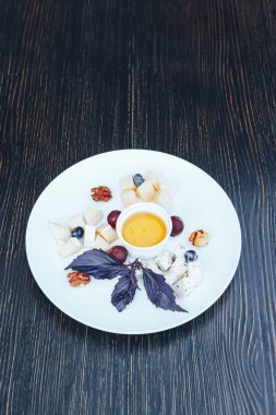 Peynir tabağı ile fındık ve bal. Ahşap bir masa üzerinde peynir tabağı