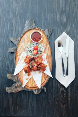 Izgara domuz etli soğan ve sosu bir ahşap tahta üzerinde. Sıcak et yemekleri. üstten görünüm