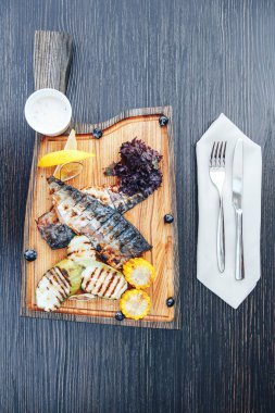 Izgara balık sebze ile ahşap kesme tahtası. ahşap arka plan. üstten görünüm