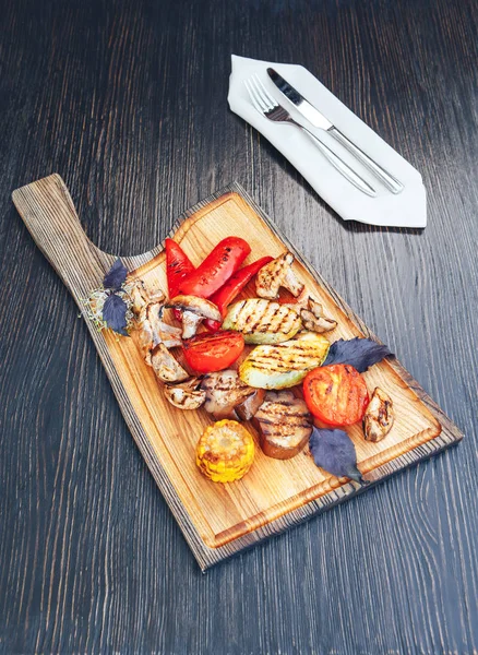 Grillezett zöldségekkel, vágódeszka, sötét fából készült háttér. grillezett zöldség mix — Stock Fotó