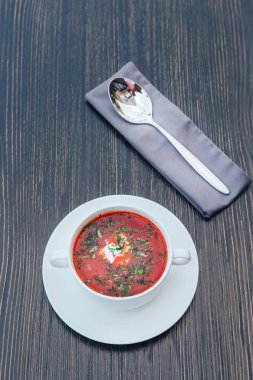 Ahşap bir masa üzerinde krema ile geleneksel Ukraynalı Rus Borsch. Rus vejetaryen kırmızı çorba beyaz kase