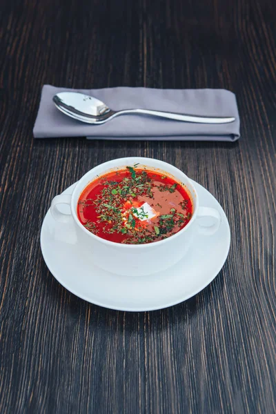 Ahşap bir masa üzerinde krema ile geleneksel Ukraynalı Rus Borsch. Rus vejetaryen kırmızı çorba beyaz kase.
