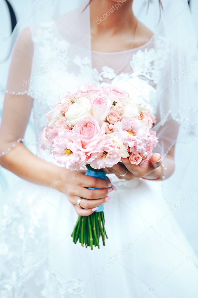 Bride holding a wedding bouquet in pastel pink colors. closeup