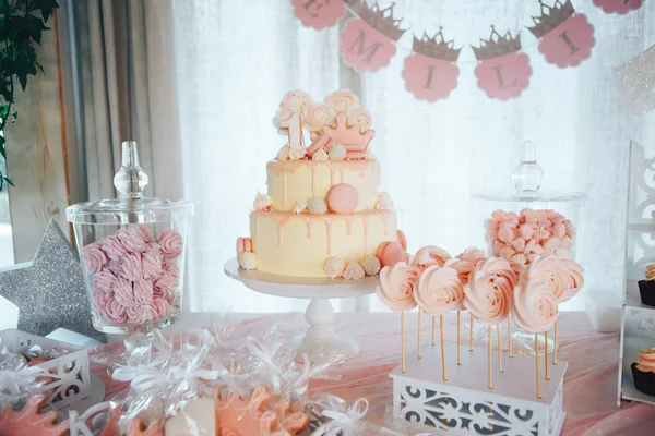 Barra de doces rosa para o primeiro aniversário. Mesa doce e bolo grande para o primeiro aniversário — Fotografia de Stock