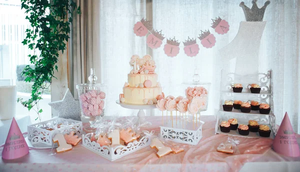 Barra de doces rosa para o primeiro aniversário. Mesa doce e bolo grande para o primeiro aniversário — Fotografia de Stock