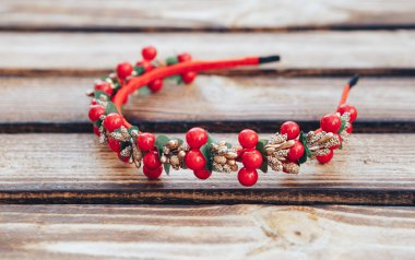 El yapımı kırmızı çiçekler hoop. Ahşap arka plan üzerinde kırmızı meyveler saç bandı