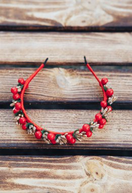 El yapımı kırmızı çiçekler hoop. Ahşap arka plan üzerinde kırmızı meyveler saç bandı. Üstten görünüm