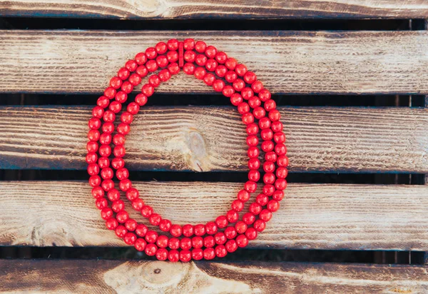 Red beads handmade. Wooden background. Top view. Ukrainian style