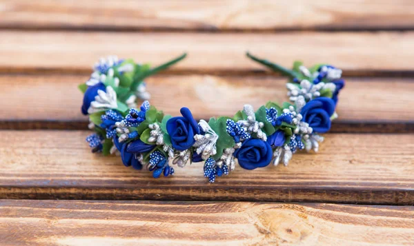 Arco feito à mão flores azuis. Faixa de cabelo azul no fundo de madeira — Fotografia de Stock