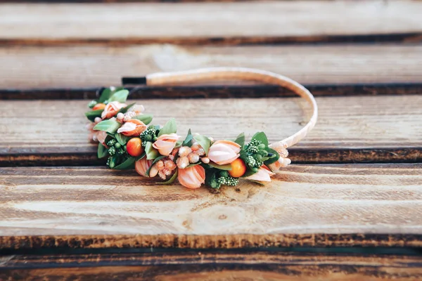 Flores de arco feitas à mão. Faixa de cabelo laranja no fundo de madeira — Fotografia de Stock