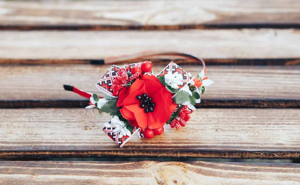 Handmade hoop flowers. Red poppies hair band on wooden background. Ukrainian style. Ukrainian ornament.