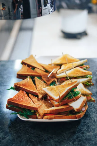 Sandwiches triangulares de pan tostado con lechuga y jamón en un plato Imagen De Stock