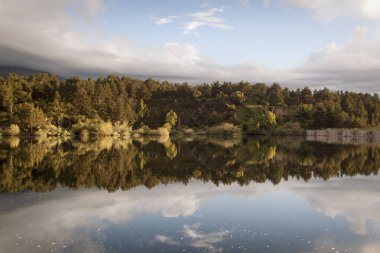 Revenga depo, Segovia, İspanya gün batımı. Su yansımalar ile altın ve gümüş tonları. Sakin sahne.