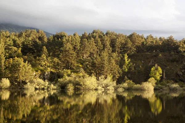 Revenga depo, Segovia, İspanya gün batımı. Su yansımalar ile altın ve gümüş tonları. Sakin sahne.