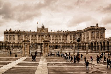 Madrid 'in Kraliyet Sarayı. İspanya, Avrupa baharda bulutlu bir gökyüzü. Sarayı ziyaret eden turistler, sokaklarda yürüyen insanlar..