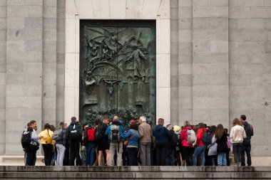 Madrid 'deki Almudena katedralinin kapısı. İspanya, Avrupa baharda bulutlu bir gökyüzü. Sarayı ziyaret eden turistler, sokaklarda yürüyen insanlar..
