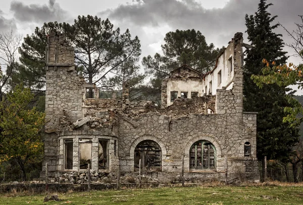 Abandoned house, stone wall with collapsed windows, in the chestnut grove of El Tiemblo, Avila. Castile and Leon, Spain