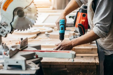 Marangoz elektrikli matkapla delik açıyor.