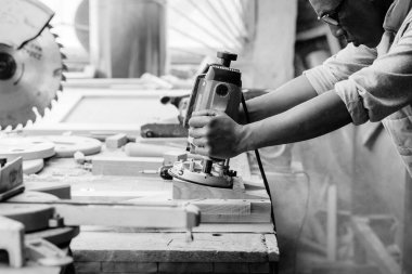 Marangozlar marangozlukta elle değirmen makinesinde çalışıyorlar.