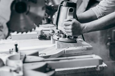 Marangozlar marangozlukta elle değirmen makinesinde çalışıyorlar.