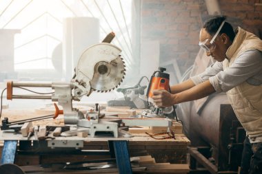 Marangozlar marangozlukta elle değirmen makinesinde çalışıyorlar.