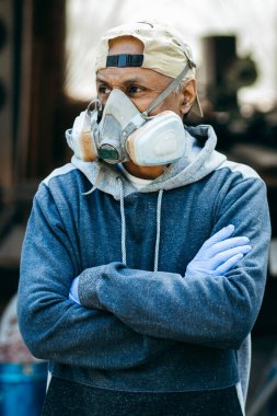 Tehlike ortamında çalışmak için tam yüz maskesi takan erkek işçilerin portresini kapat.. 