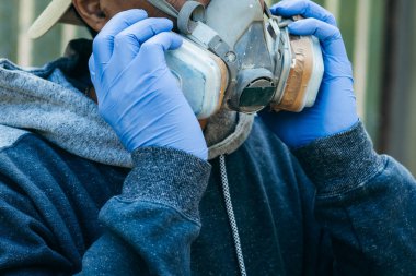 Tehlike ortamında çalışmak için tam yüz maskesi takan erkek işçilerin portresini kapat.. 