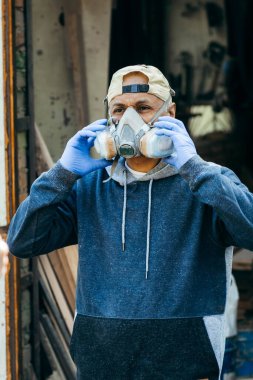 Tehlike ortamında çalışmak için tam yüz maskesi takan erkek işçilerin portresini kapat.. 