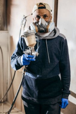 Fabrikada usta bir ressam. Endüstriyel odunları sprey silahla boyuyor.. 