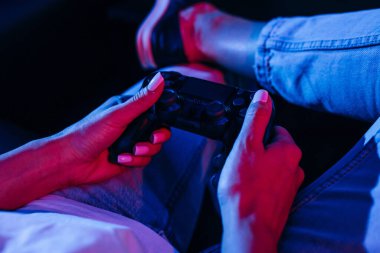 Oyun sahasını tutan ve video oyunları oynayan kadınların ellerini kapat