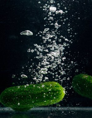 Siyah arka planda yeşil salatalıklar..